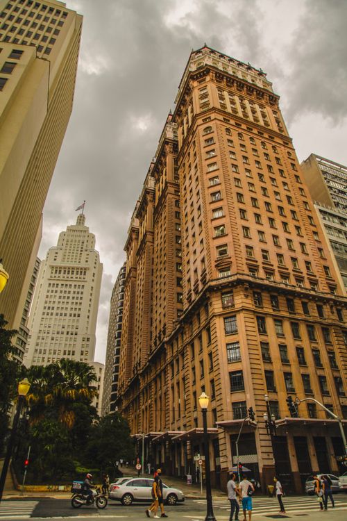 Free Dramatic cityscape of historic skyscrapers with people and traffic in urban setting. Stock Photo