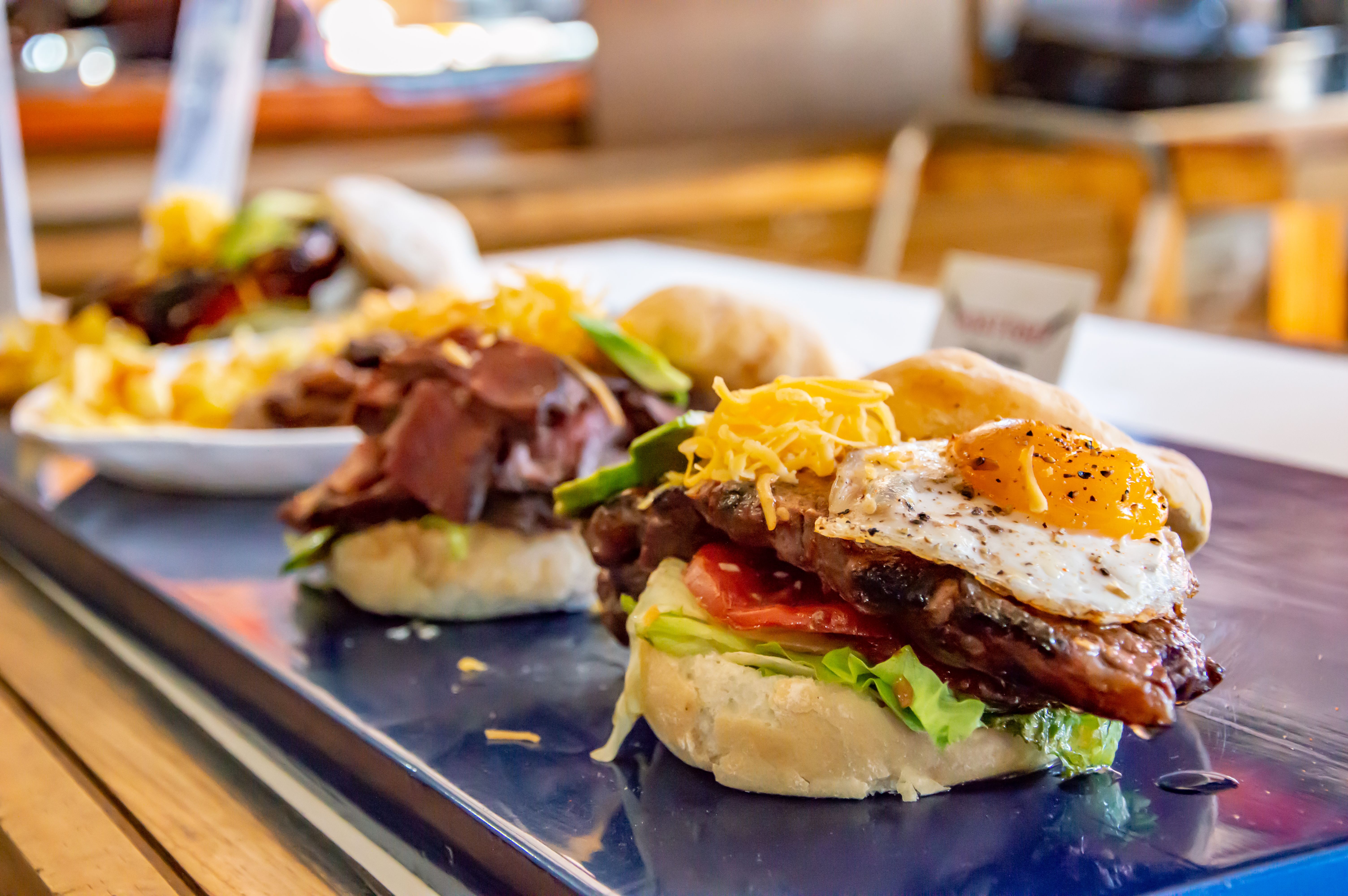 the towering Wolf Burger with a fried egg on top - Best burgers Uptown