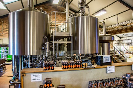 Interior of a brewery showcasing large stainless steel tanks and bottled beverages on display.