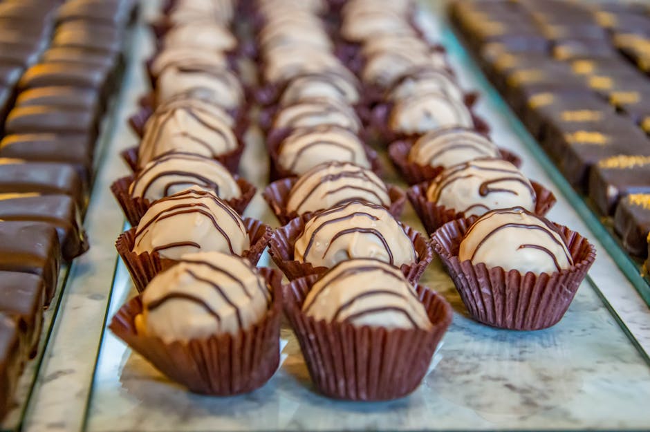 Delicious gourmet chocolate truffles displayed in rows, perfect for dessert lovers and bakery settings.