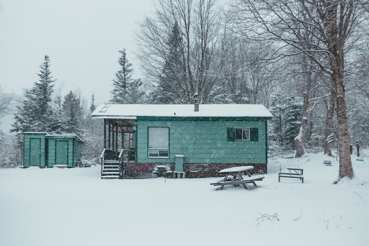 House And Storage Cabins In Snowy Forest In Winter