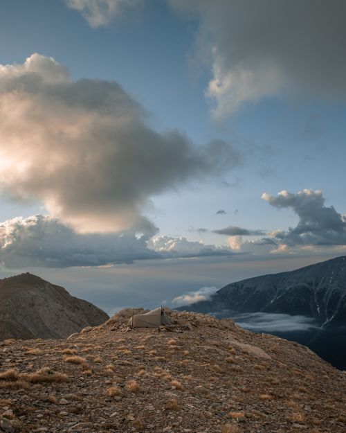 Free Experience the serenity of a lone tent atop Mount Olympus under a vast blue sky. Stock Photo