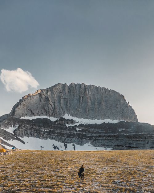 Free A breathtaking view of Mount Olympus with a lone hiker, capturing the grandeur of Greece's iconic landscape. Stock Photo