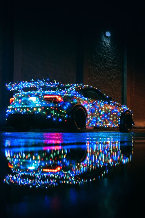 Colorful Lights Wrapped Around a Coupe Car ยท Free Stock Photo