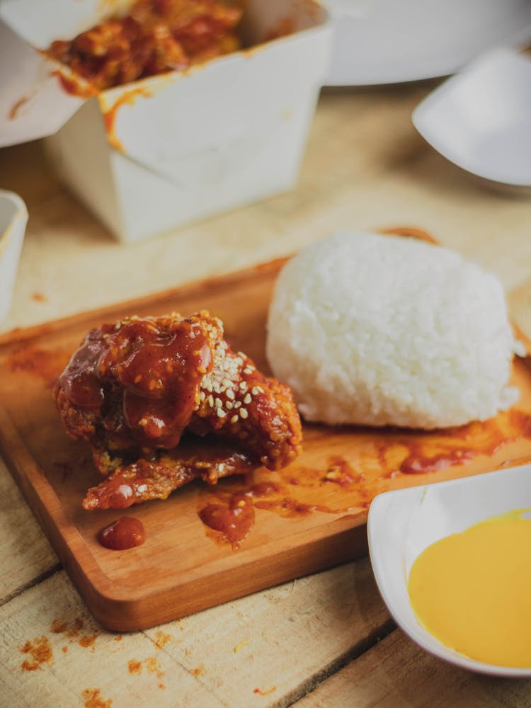 A Spicy Chicken Topped With Sesame Seeds Paired With Rice