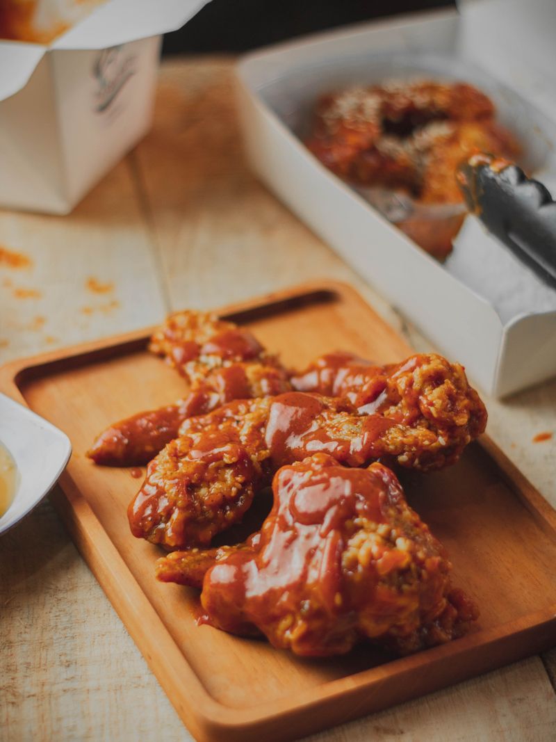 Crispy fried chicken glazed in glossy red hot sauce