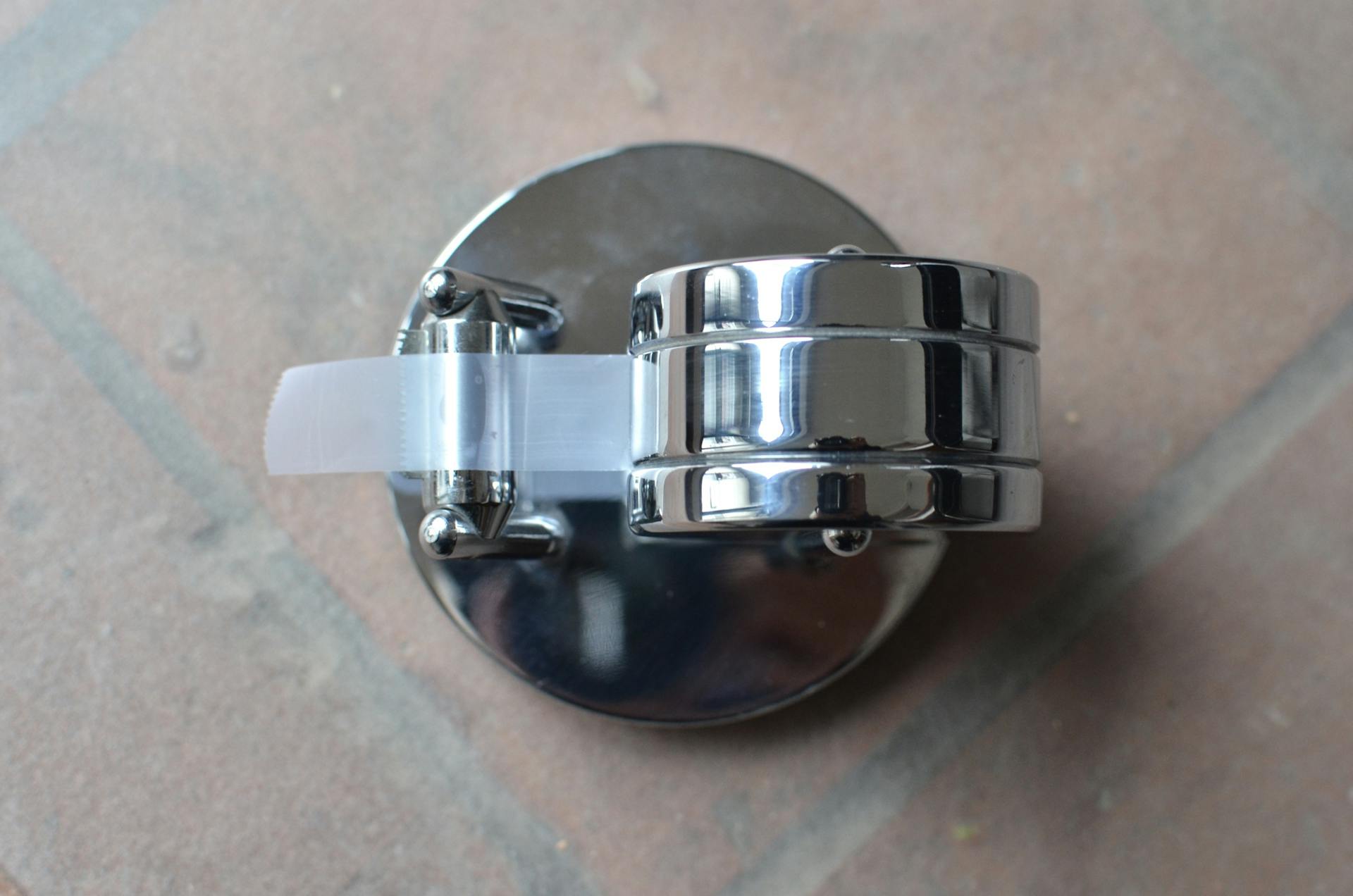 Top view of metal automatic dispenser with blade for cutting adhesive plastic tape
