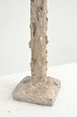 High angle of clay sculpture with curved relief placed on white surface at exhibition