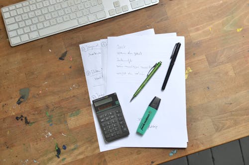 Free Calculator and pens with marker placed on papers Stock Photo