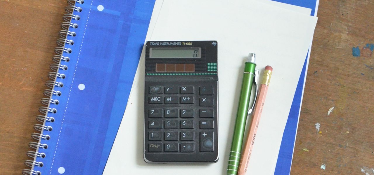 Notebook, calculator and pens on a desk