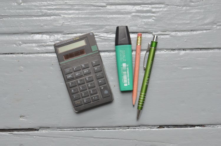 Calculator Near Stationery On White Table