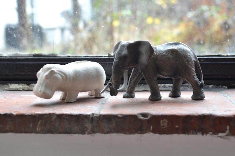 Statuette Of Elephant And Hippopotamus On Windowsill