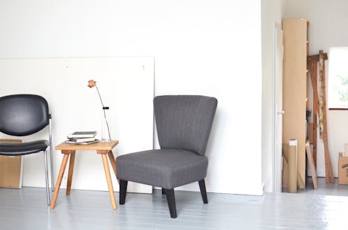 Chairs and table placed near white wall in modern workshop