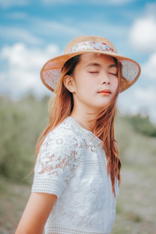 Dreamy Asian female enjoying windy day