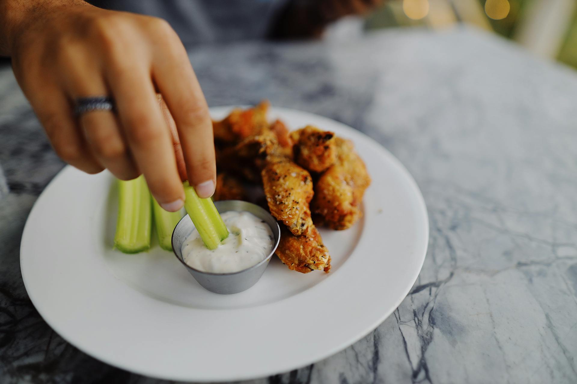 Person Dipping Celery on a Ranch Dip