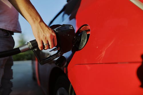 Free A Person Filling Up a Red Car with Gas  Stock Photo