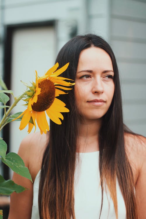 Free Portrait of a Woman With a Sunflower Stock Photo