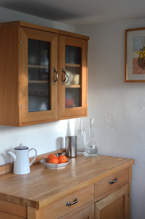 Kitchen counter with different utensils and cupboard for dishes