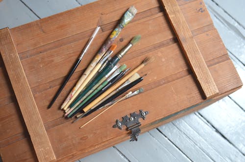 Messy paintbrushes placed on wooden box