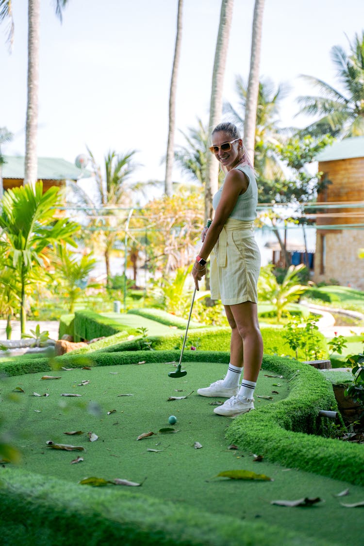 A Woman Playing Golf In A Mini Golf Course