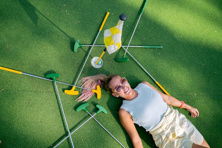 Woman Lying Next To Putters 