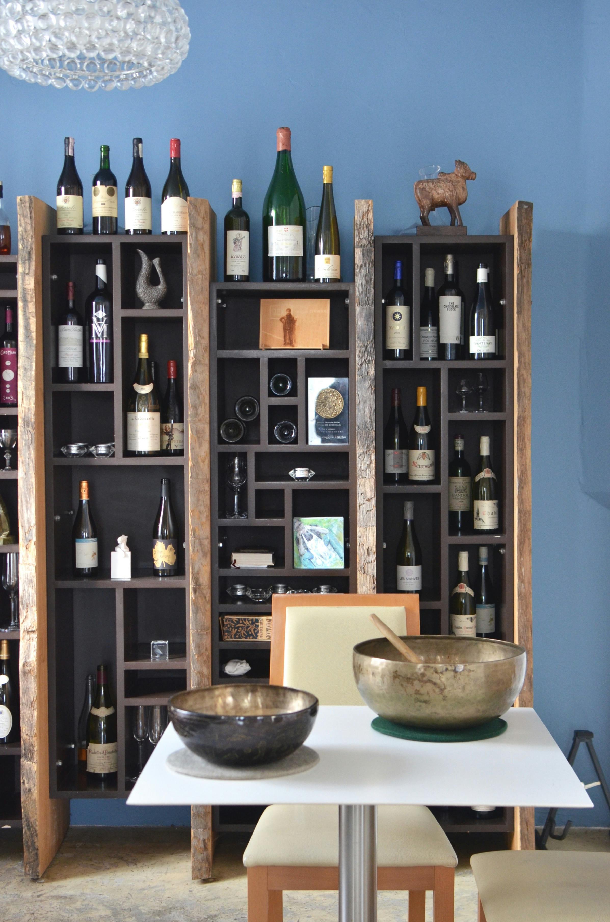 Cupboard with wines collection and table with bowls in cafe · Free