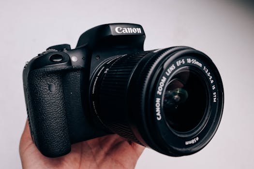 A close-up shot of a DSLR camera being held, showcasing its lens details.