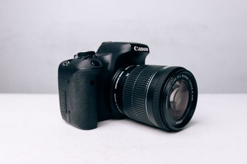 Free Close-up of a DSLR camera with zoom lens on a white background, ideal for photography concepts. Stock Photo