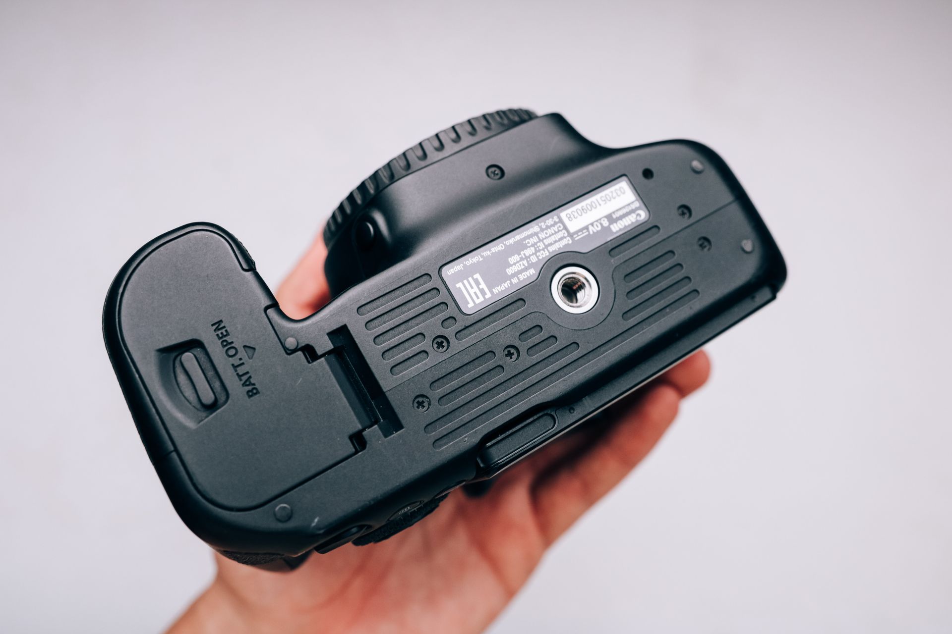 A Person Holding a Black Canon Camera Showing the Camera Specs