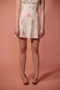 A Woman in White and Pink Floral Dress Twisting Her Ankles