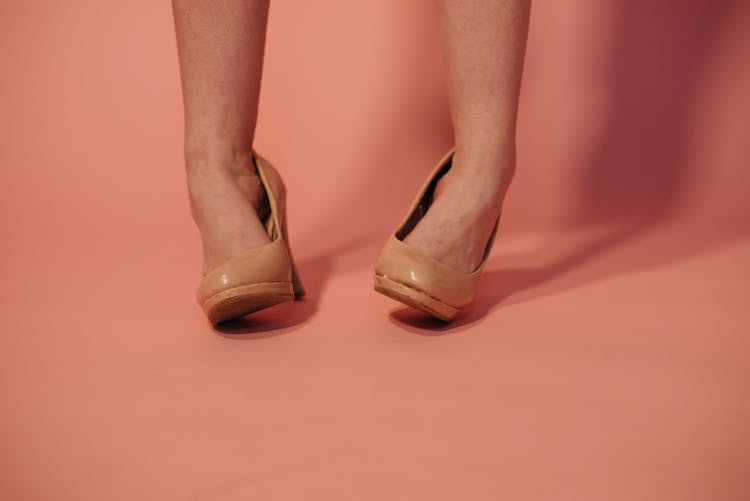 A Woman Wearing Brown High Heels Twisting Her Ankles