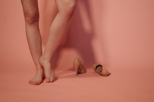 A Barefooted Person Standing with Curled Toes on the Floor