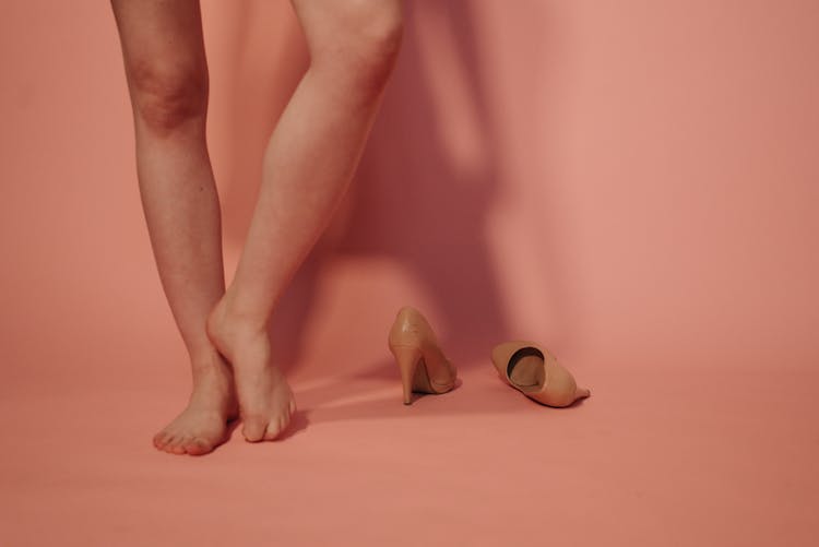 A Barefooted Person Standing With Curled Toes On The Floor