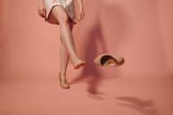 A Woman in White Dress Kicking Off her Shoe