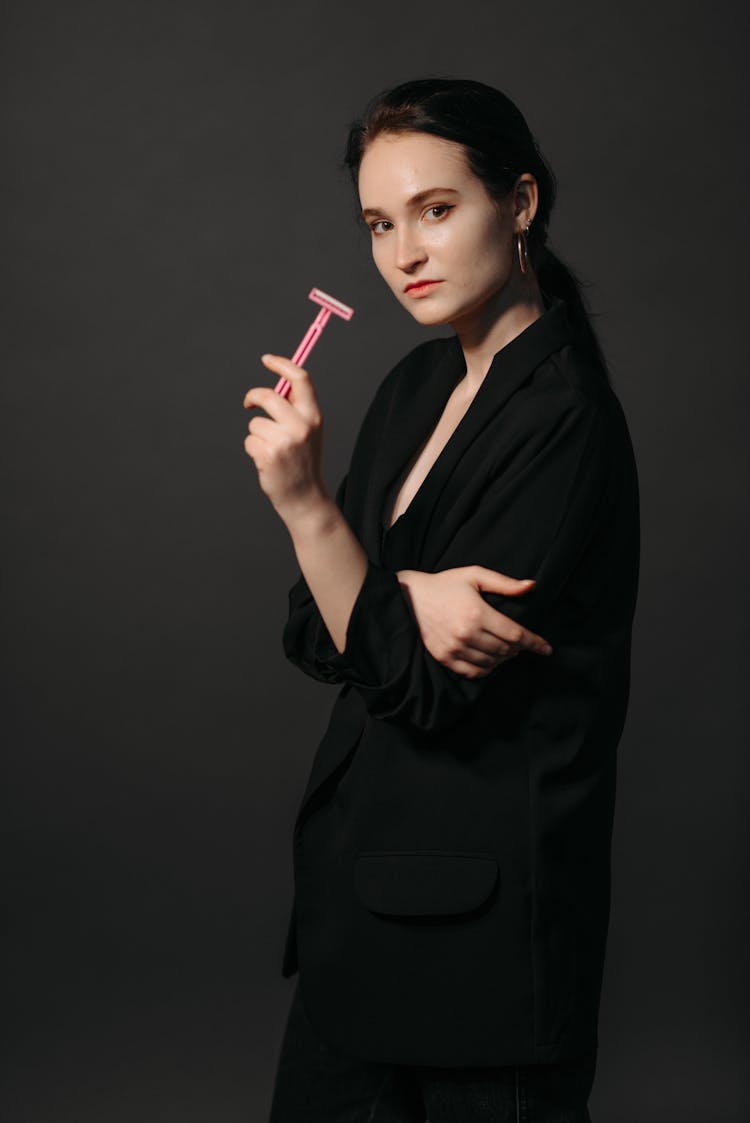 Woman In Black Blazer Holding A Razor