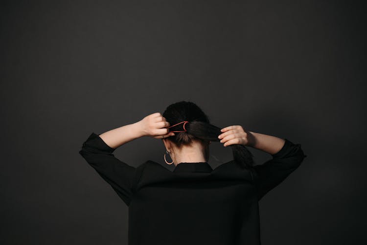 A Woman Tying Her Hair With A Hair Band