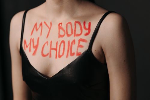 Free Close-up of empowering feminist slogan 'My Body My Choice' on woman's chest in black dress. Stock Photo
