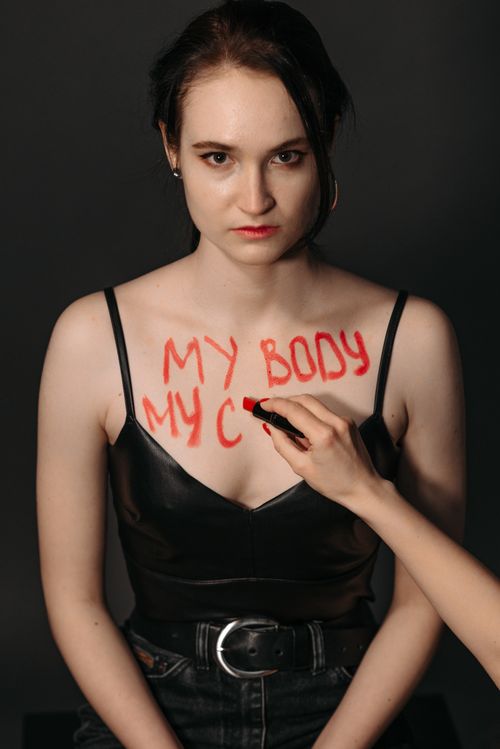 Free Portrait of a woman with a feminist message written on her chest, highlighting empowerment and choice. Stock Photo