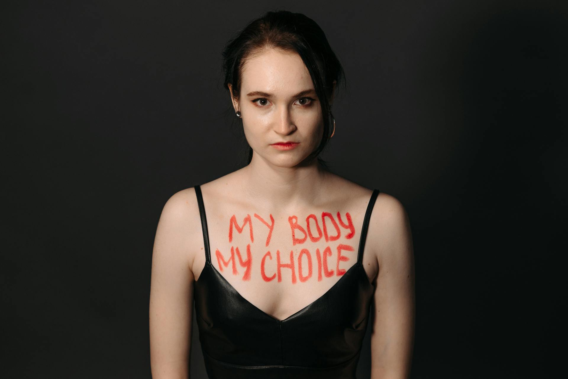 A woman with 'My Body My Choice' written on her skin, empowers choice in a studio setting.