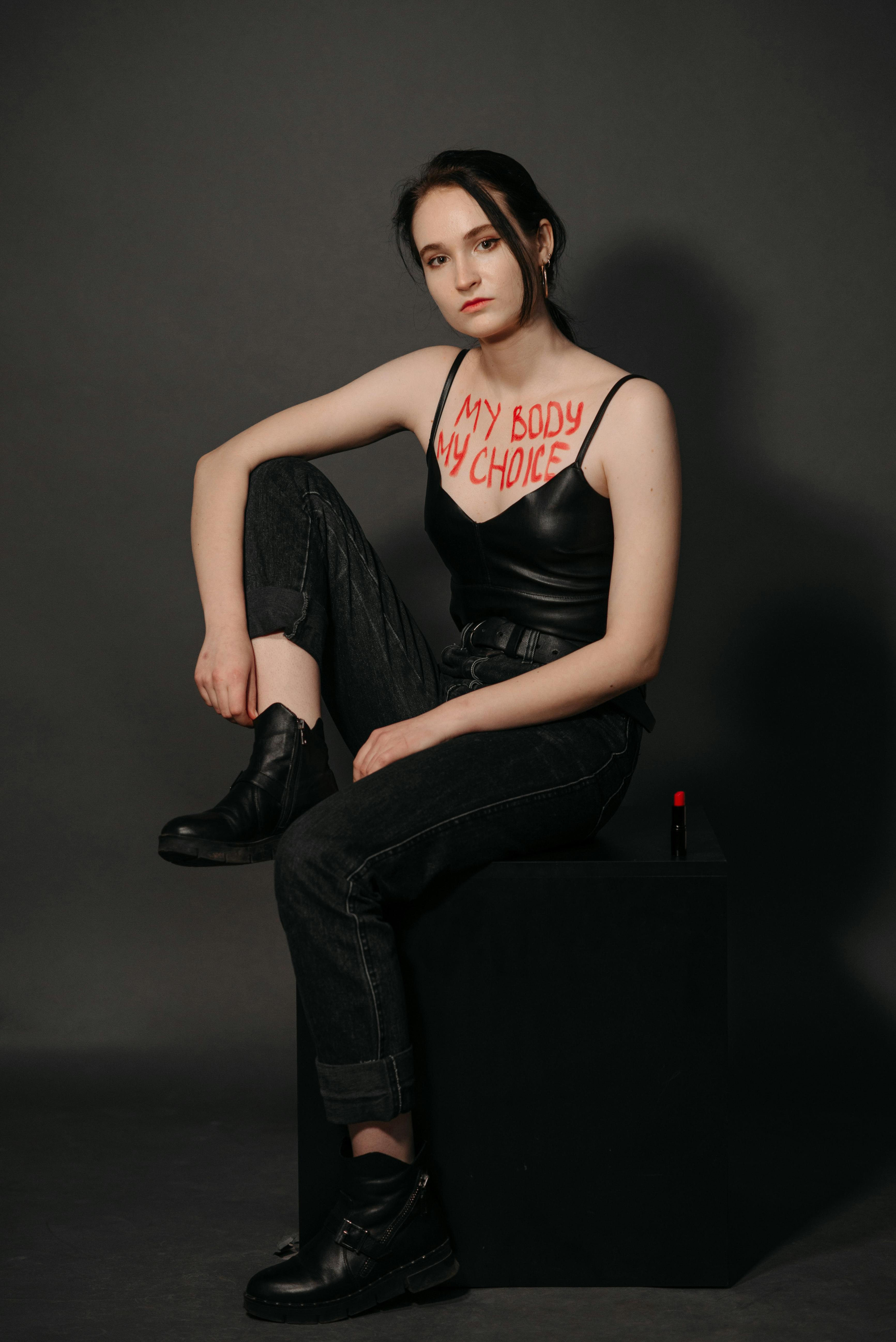 woman posing with a message written on her chest