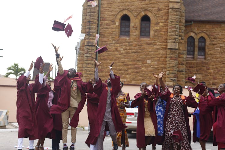 Group Of Graduate Students Throwing Their Graduation Caps