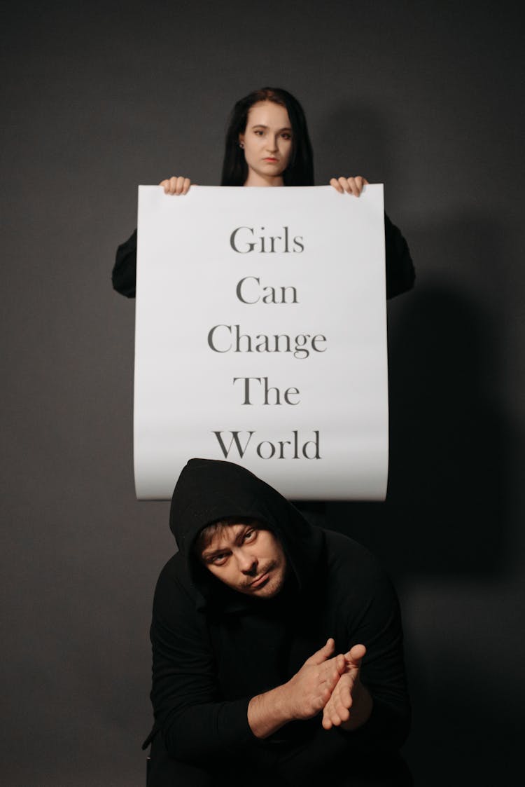 Woman Holding Banner Over Man