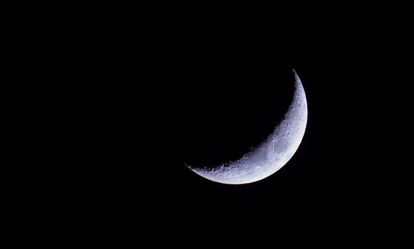 A stunning crescent moon captured against a dark night sky, perfect for astronomy enthusiasts.