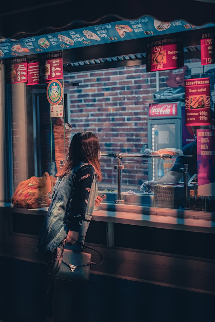 Woman Buying Food At Street Restaurant At Night