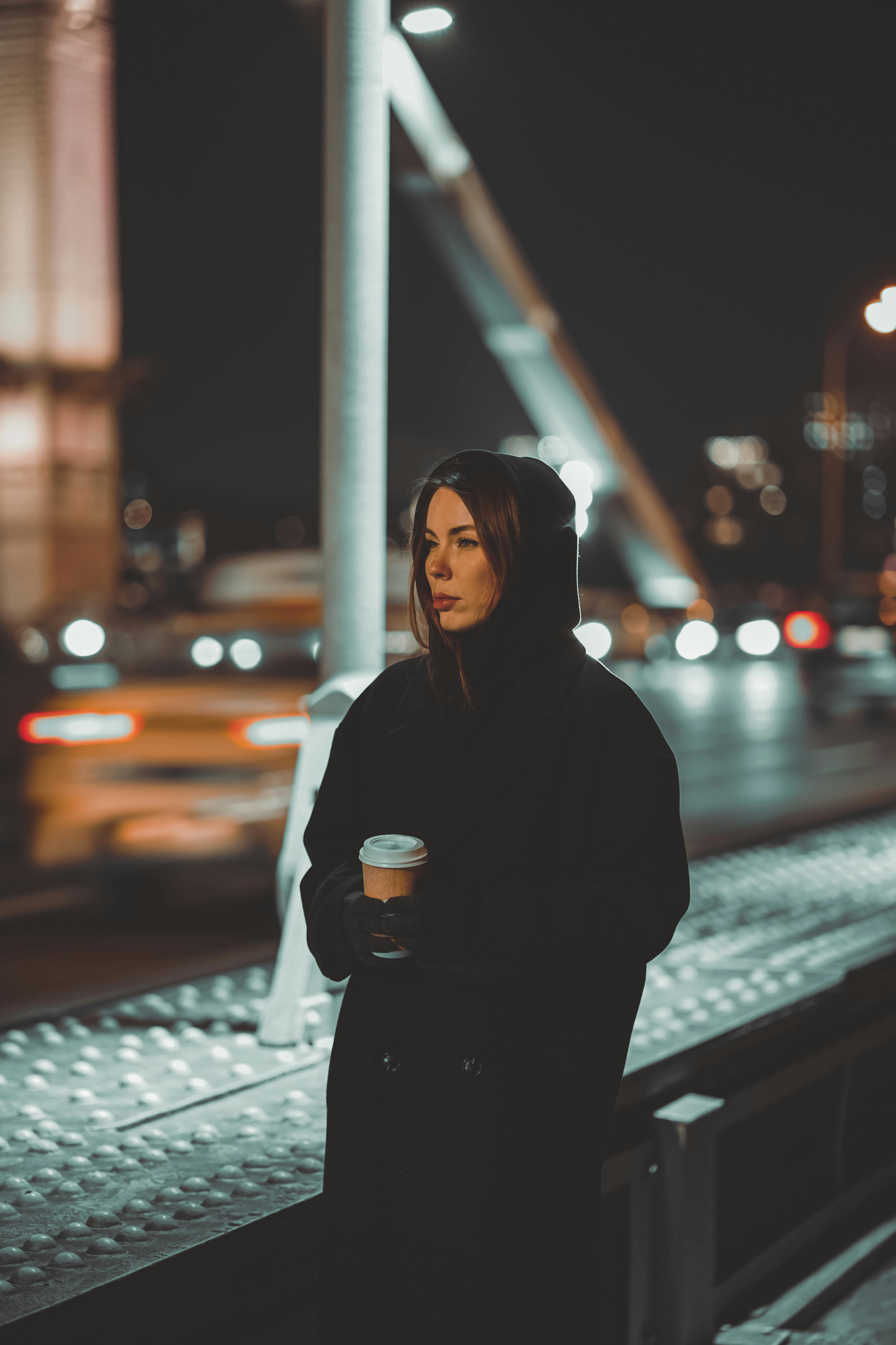 hooded woman waiting outdoors at night