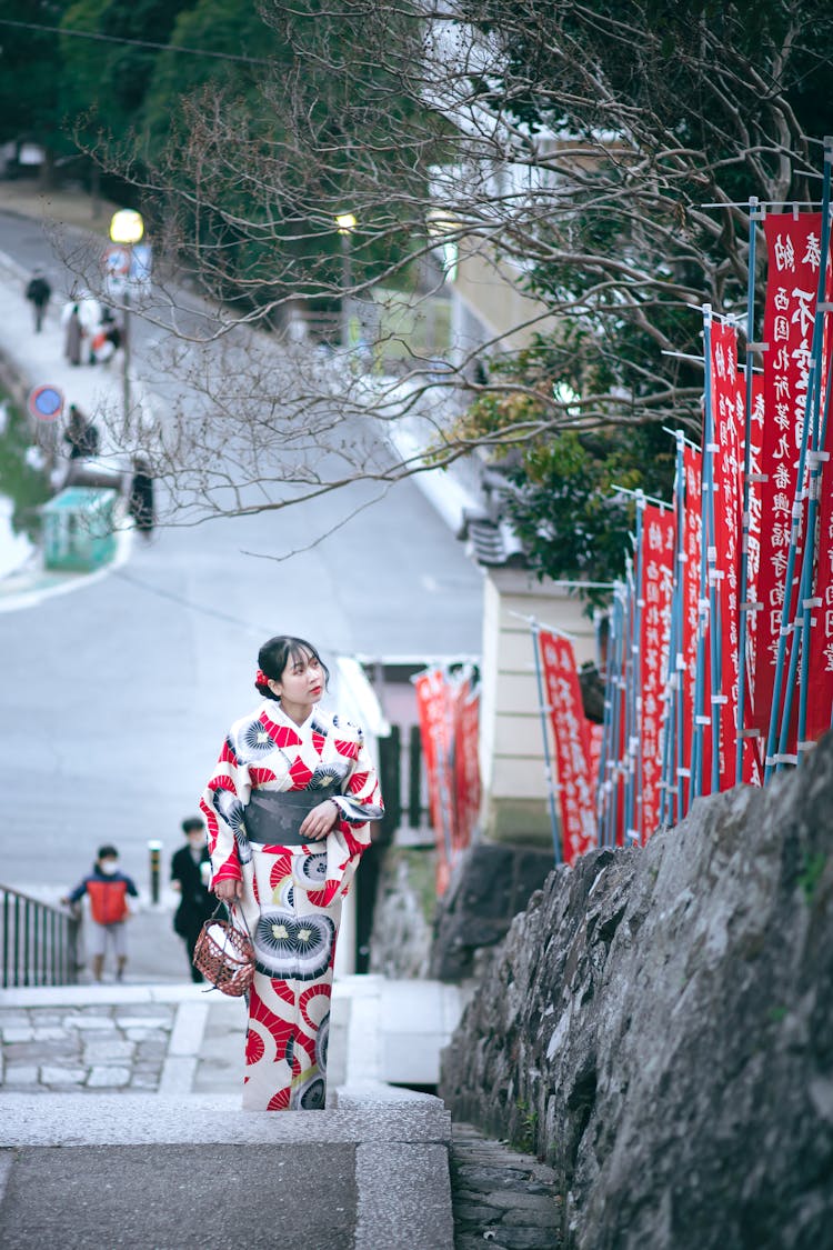 A Woman In Kimono Walking While Going Upstairs