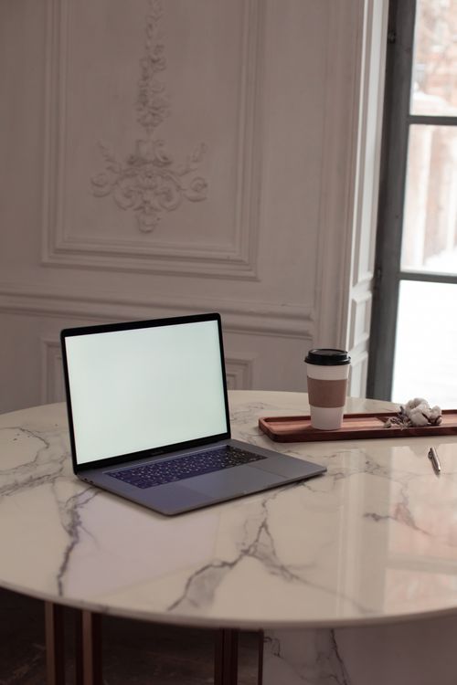 Free Elegant workspace with a laptop on a marble table and coffee cup, perfect for business concepts. Stock Photo