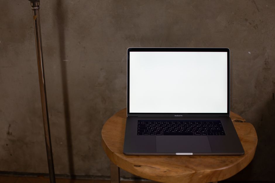 A laptop with blank screen on wooden table, perfect for mockup and design projects.