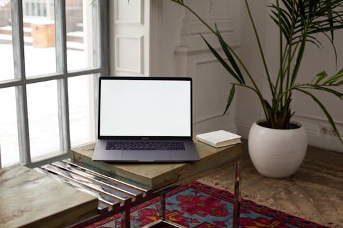 Free Macbook Pro on Brown Wooden Table Stock Photo