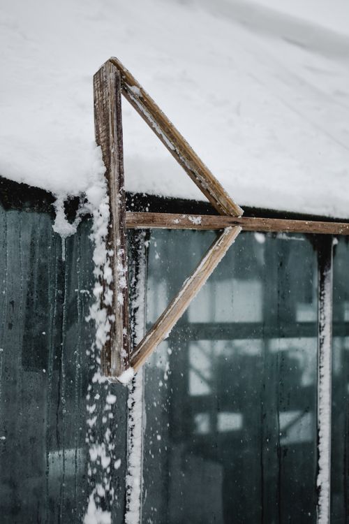 Free A close-up of snow accumulating on a wooden framed glass roof during winter in Estonia. Stock Photo